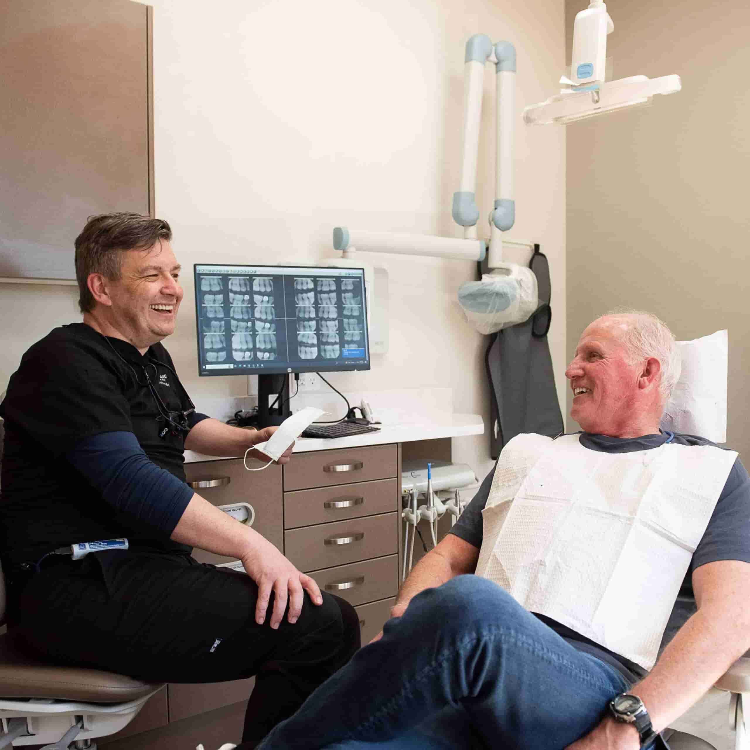 Dentist that listens - man sitting with dentist smiling.